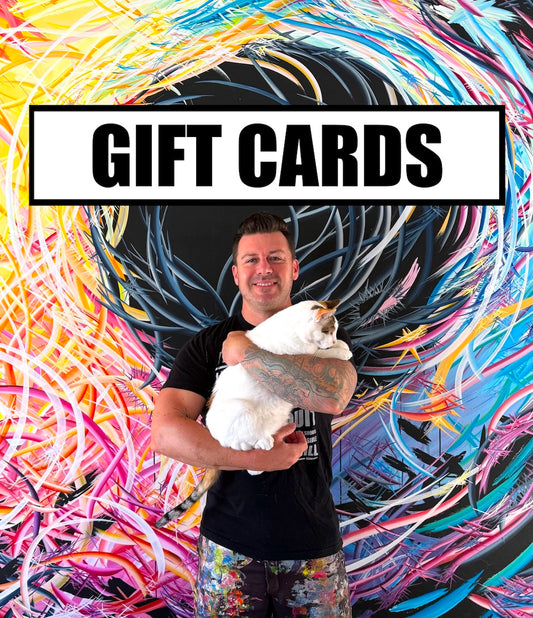 Michael Carini holding his cat Braska in front of a colorful painting - Carini Arts Gift Cards